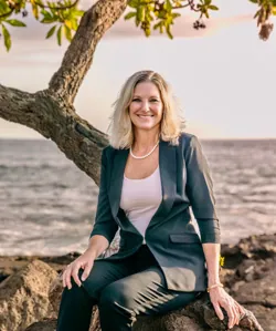 Dr. Melissa M. Nitta, DDS, seated beside the ocean in Hawaii
